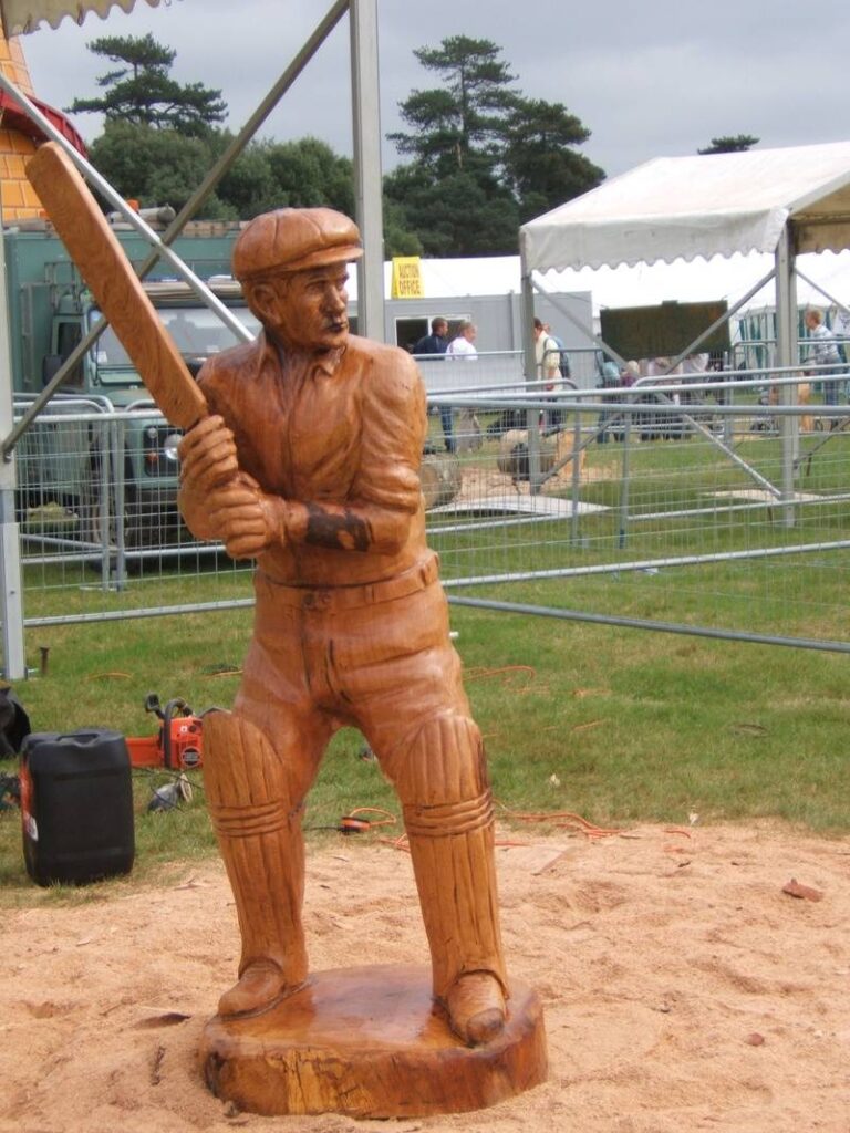 To win an English Chainsaw carving competition, John Brady carves a british cricketer